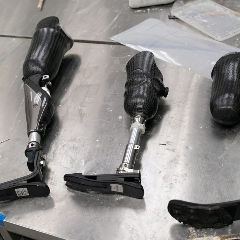 Production of a prosthetic leg. A woman creates part of the leg. An engineer is testing the mechanical joint of a prosthetic leg. New sports body part.